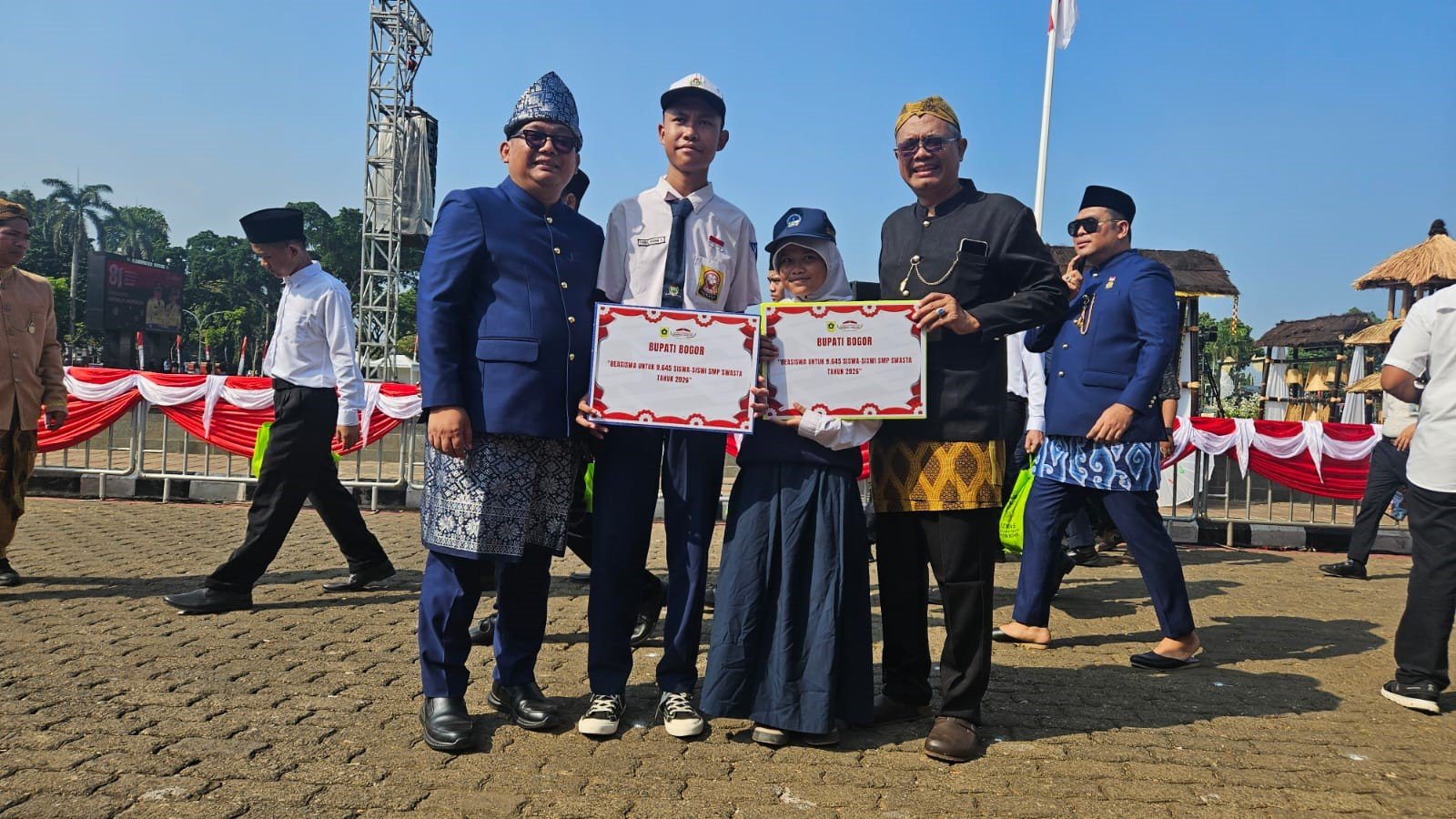 (Kepala Dinas Pendidikan (Kiri) didampingi Kepala Bidang Pembinaan SMP (Kanan) sedang berfoto bersama siswa penerima program beasiswa)