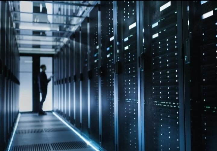 Visual gedung data center dengan simbol grafik investasi, rupiah/dolar, dan dokumen/regulasi. (Foto: Ilustrasi)